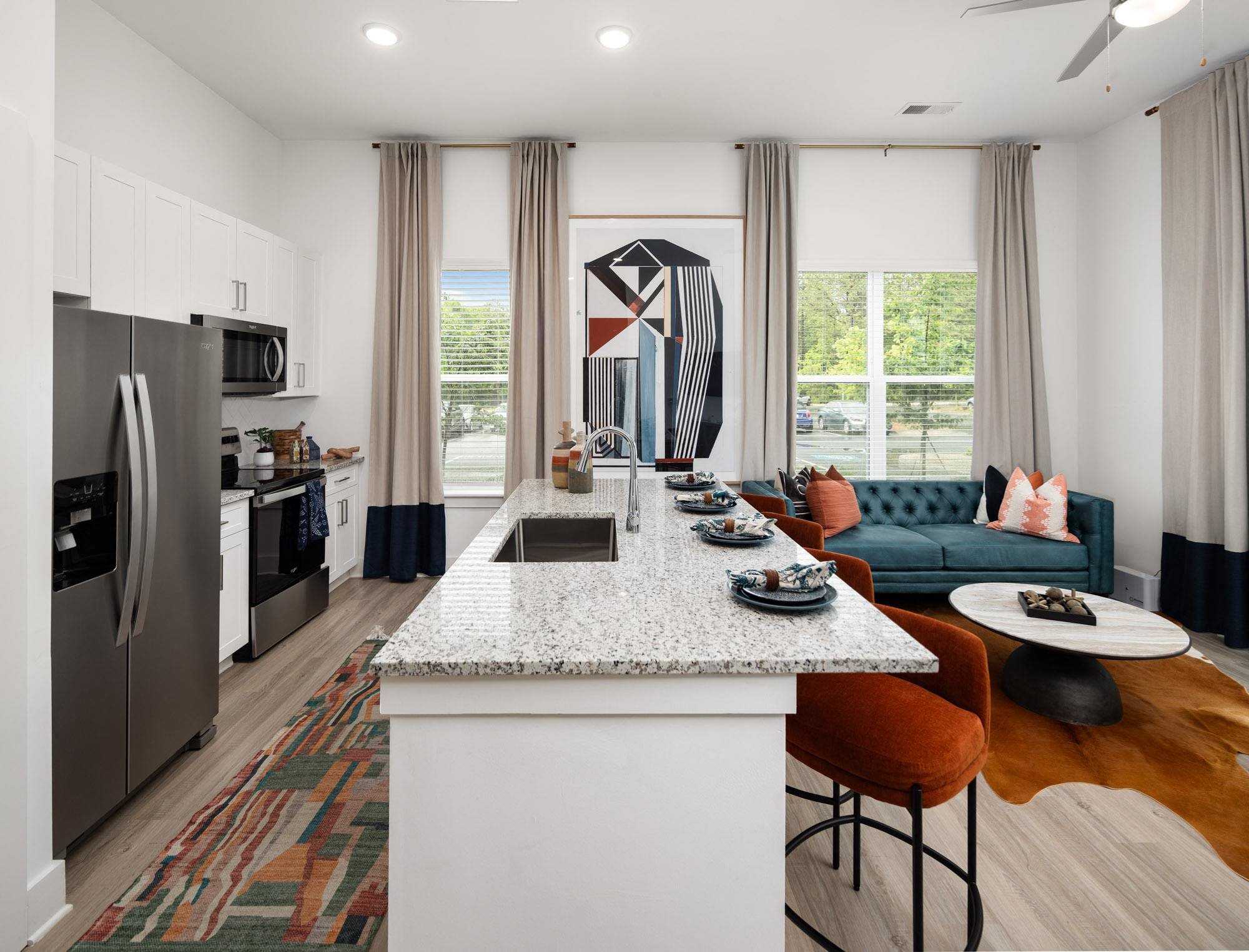 a kitchen and living room with a granite counter top and a large window